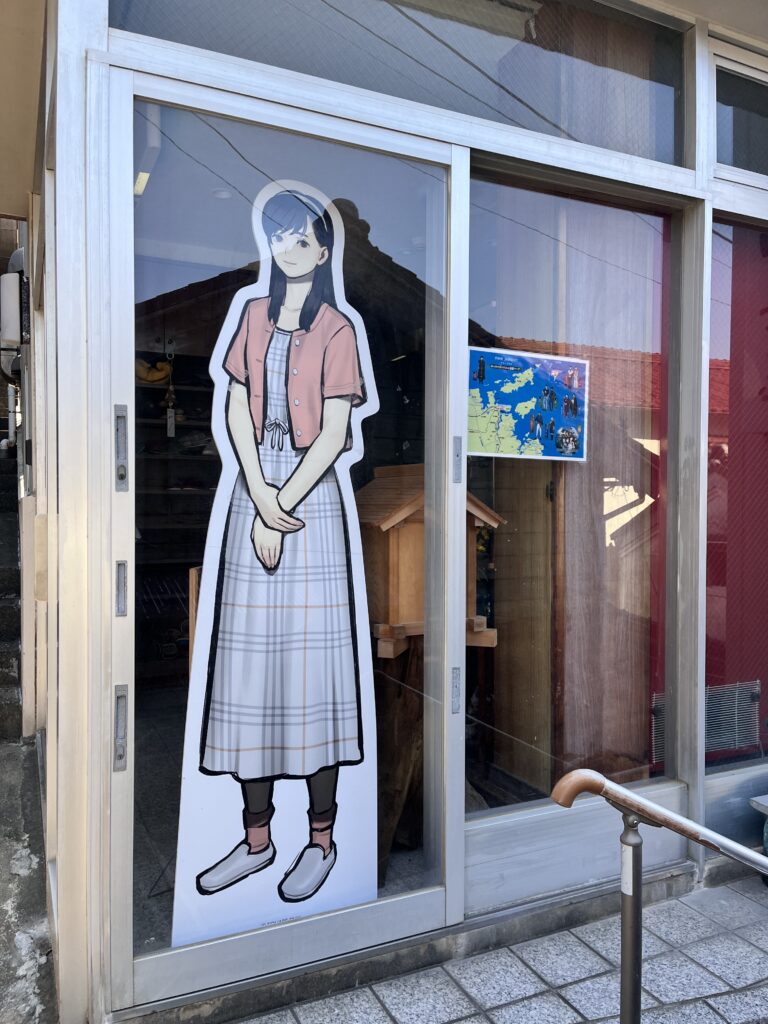 潮騒の宿「山海荘」の入り口に佇む『パラノマサイト 伊勢人魚物語』白浪里の等身大パネル